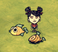 Walani standing next to a Pierrot Fish and a Cooked Pierrot Fish on the ground.